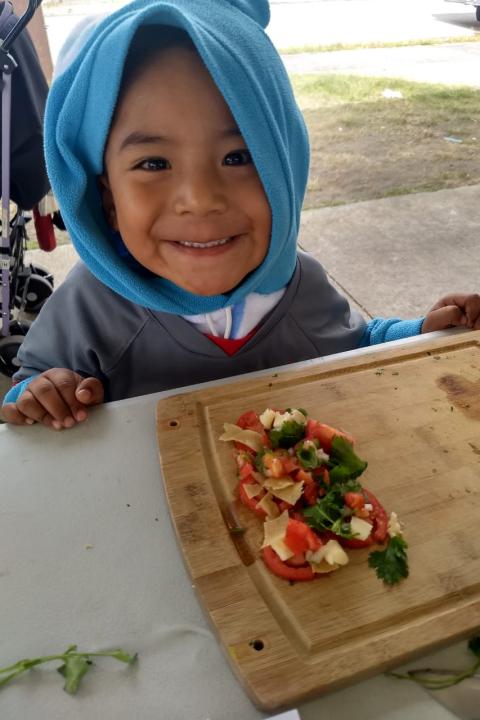 Boy in the kitchen helping to prepare fresh produce - BAMX food bank network fights food insecurity in Mexico